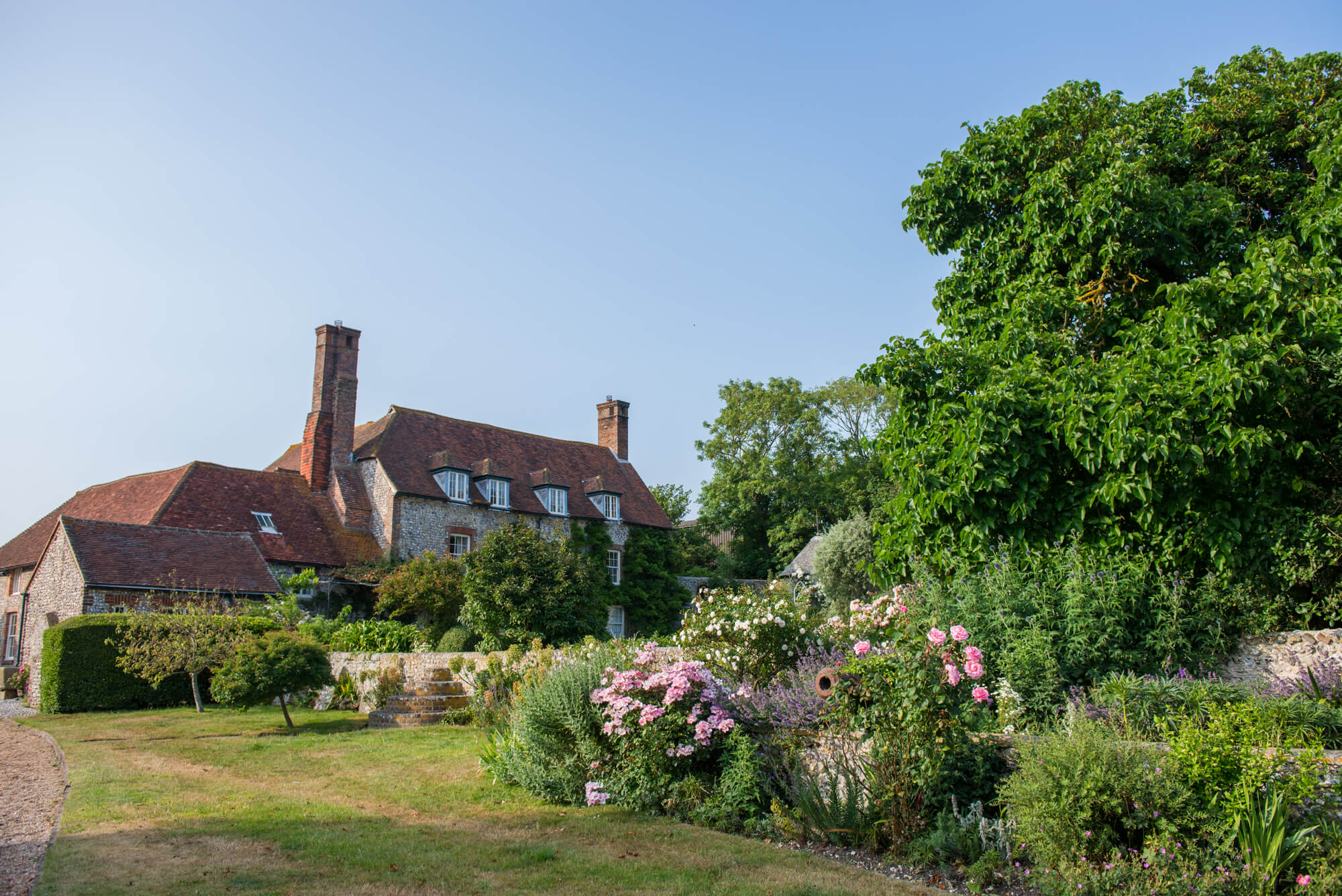 Birling Manor in the sunshine surrounded by lush green gardens