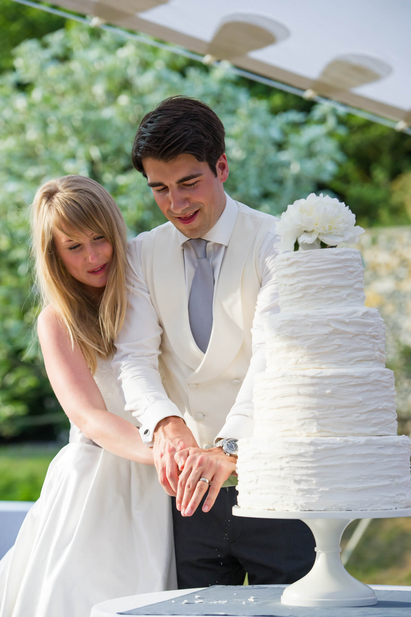 A bride and groom cutting their 4 tier wedding cake at Birling Manor