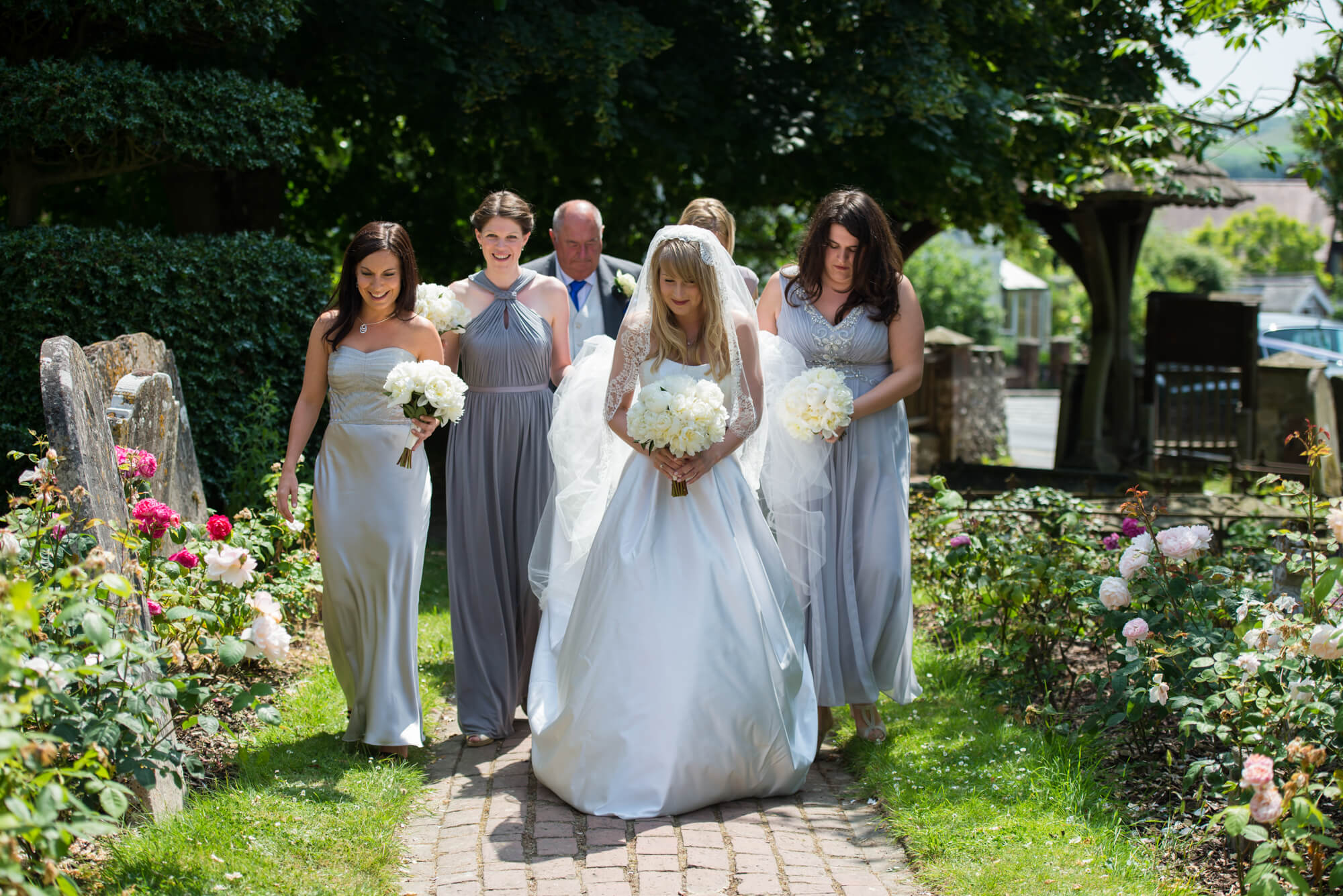 A bride walking into church wearing her Suzanne Neville dress