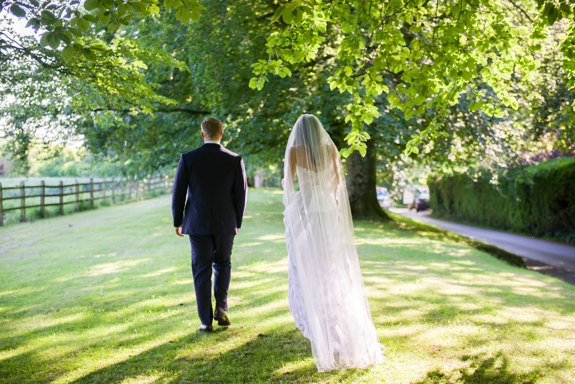 bride and groom walking under the trees at babington house