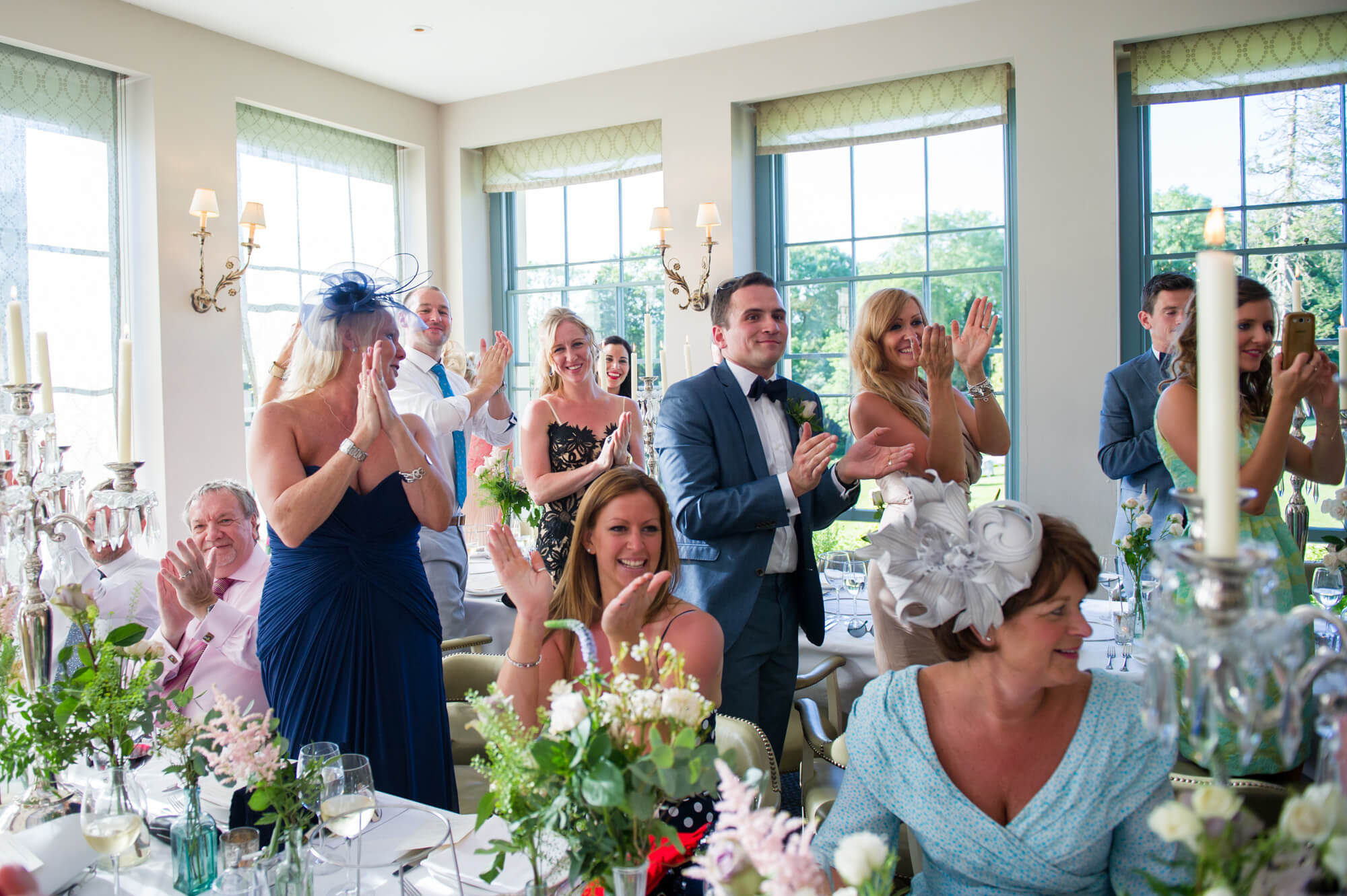guests clapping to welcome bride and groom for wedding breakfast