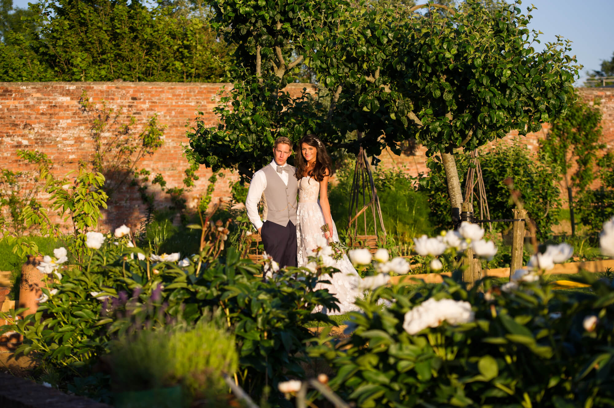 bride and groom in the walled garden at babington house during sunset