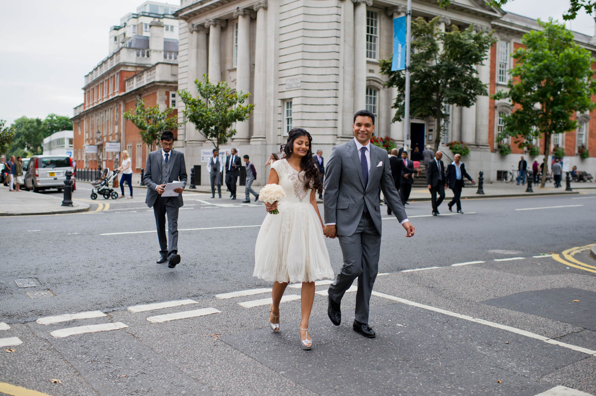 A couple walking through London on their wedding day