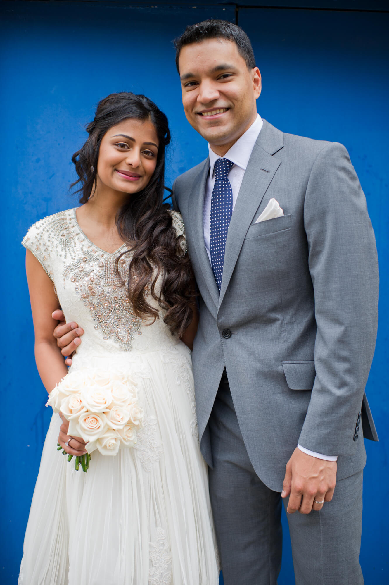 A bride and groom standing in front of a blue door