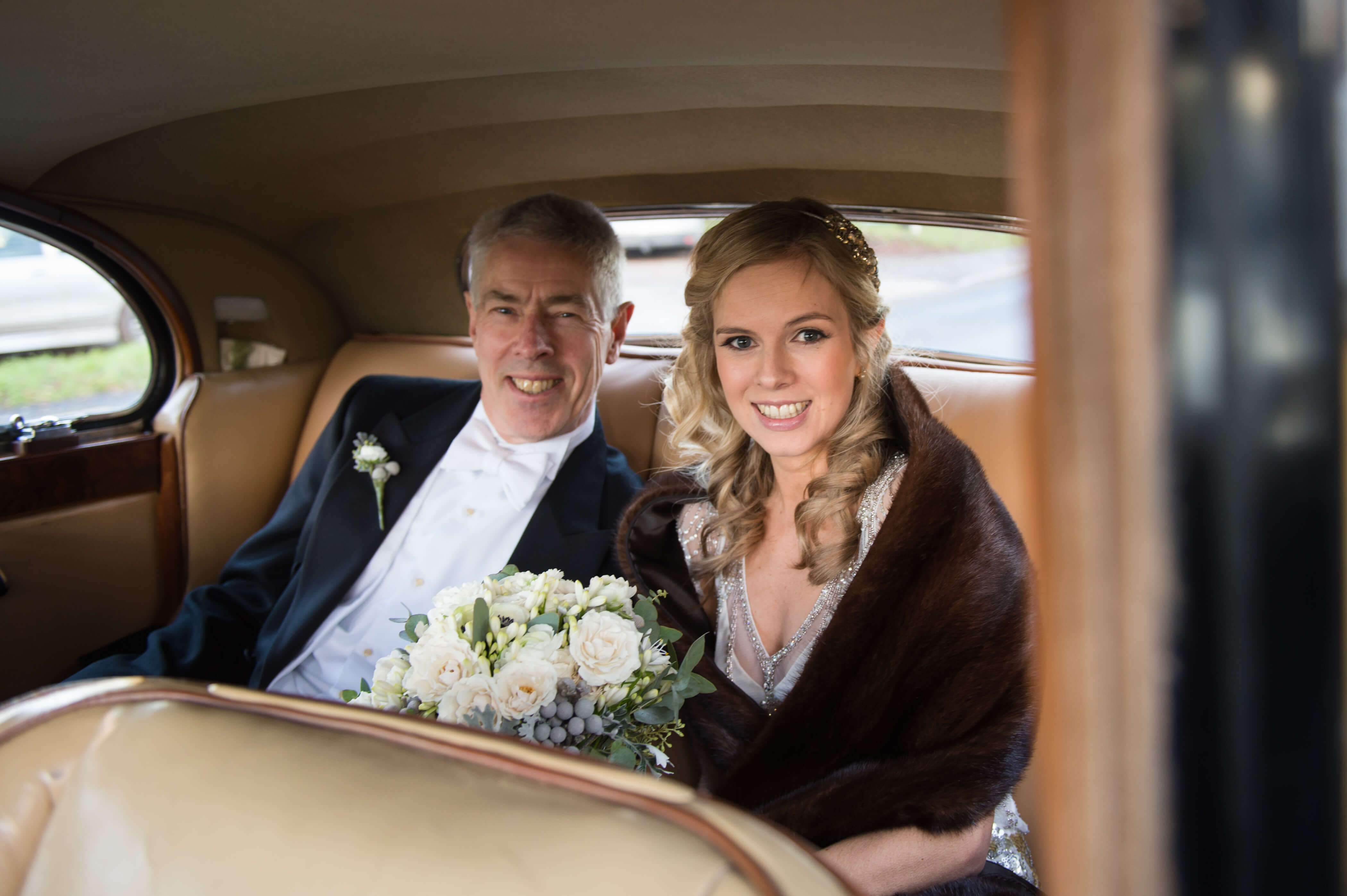 The bride and her father inside a vintage wedding car on their way to be married