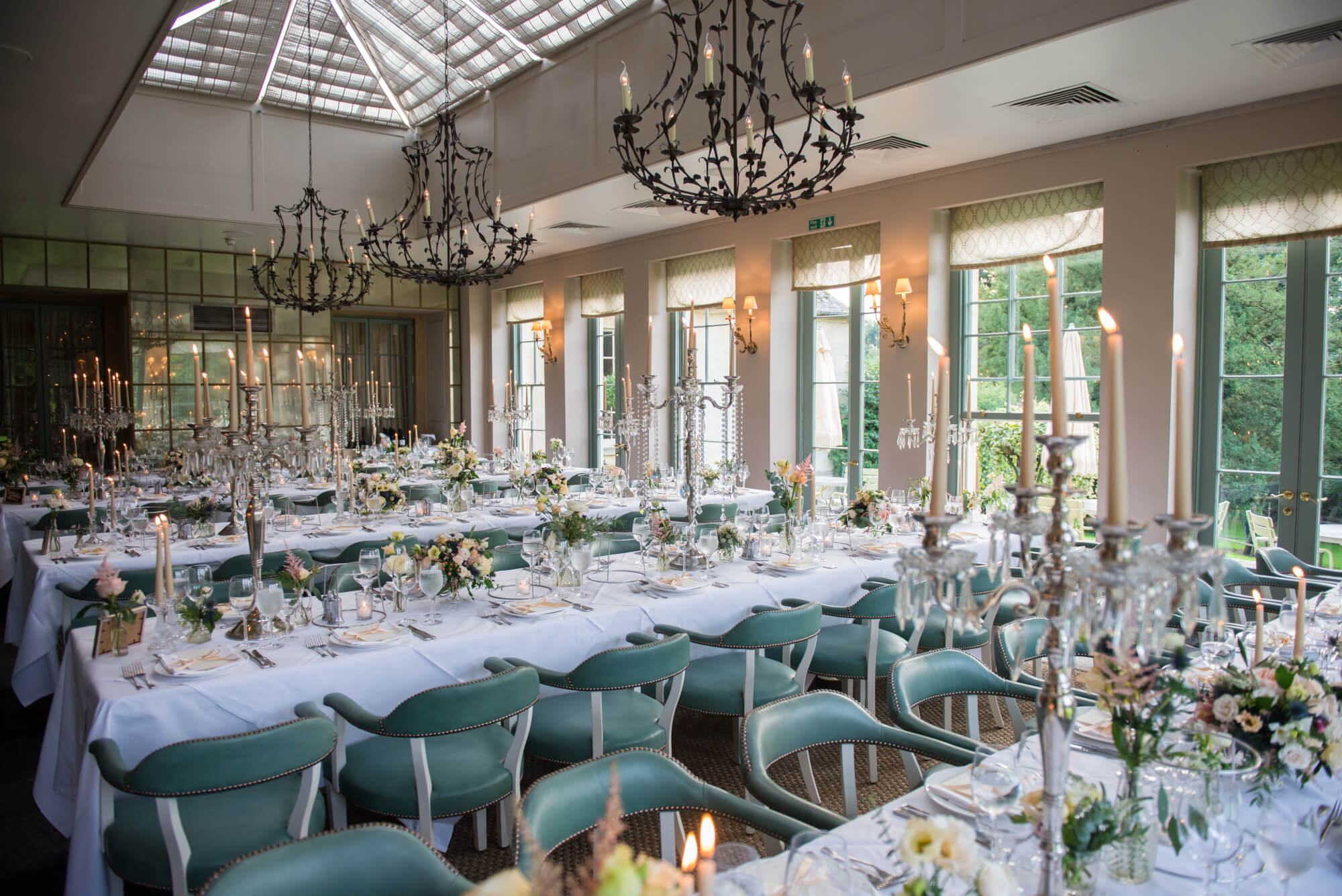 candlelit reception tables at babington house wedding in the orangery flowers by passion