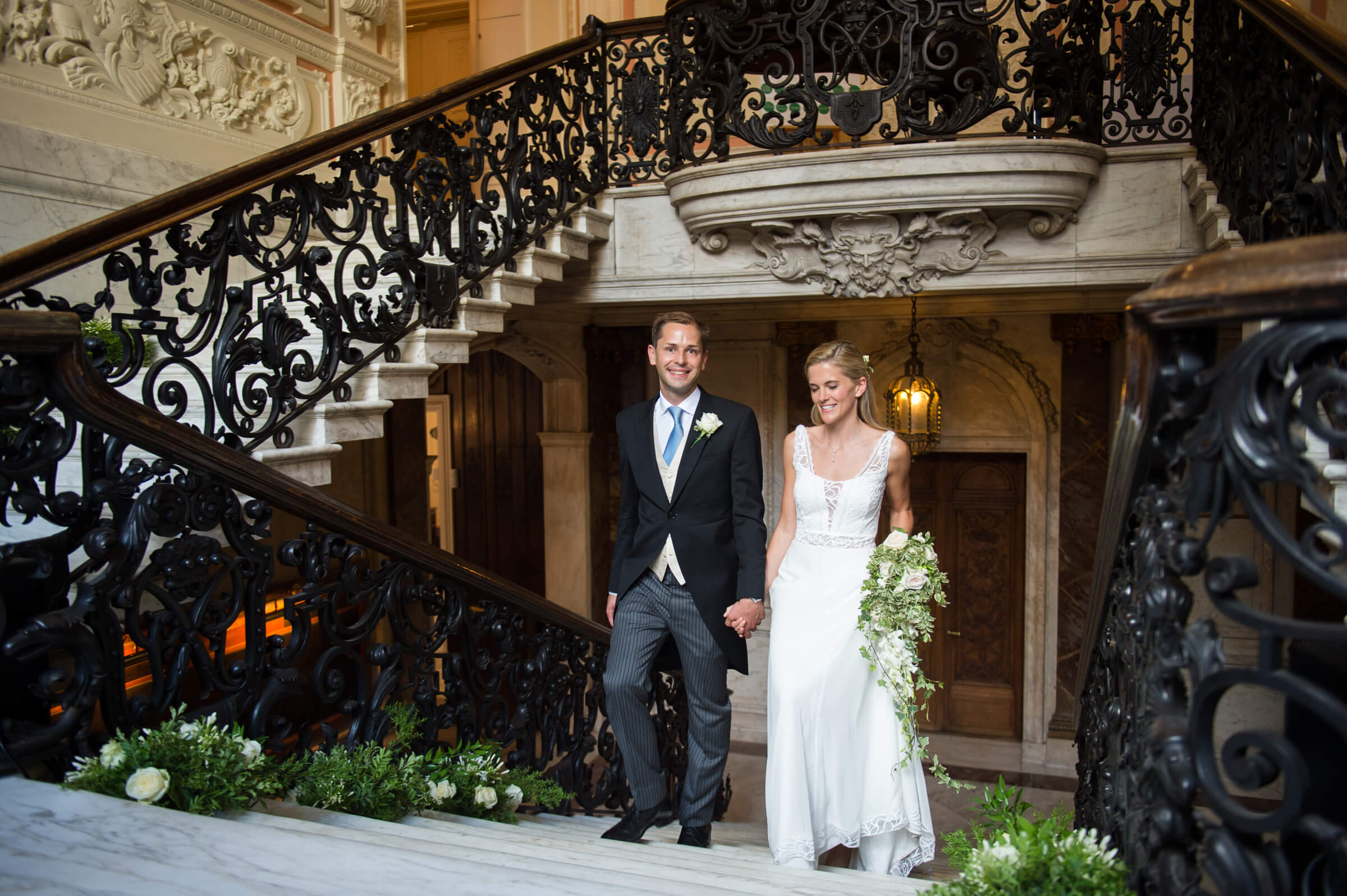 Bride and groom walking up the stair case at Dartmouth house in London 