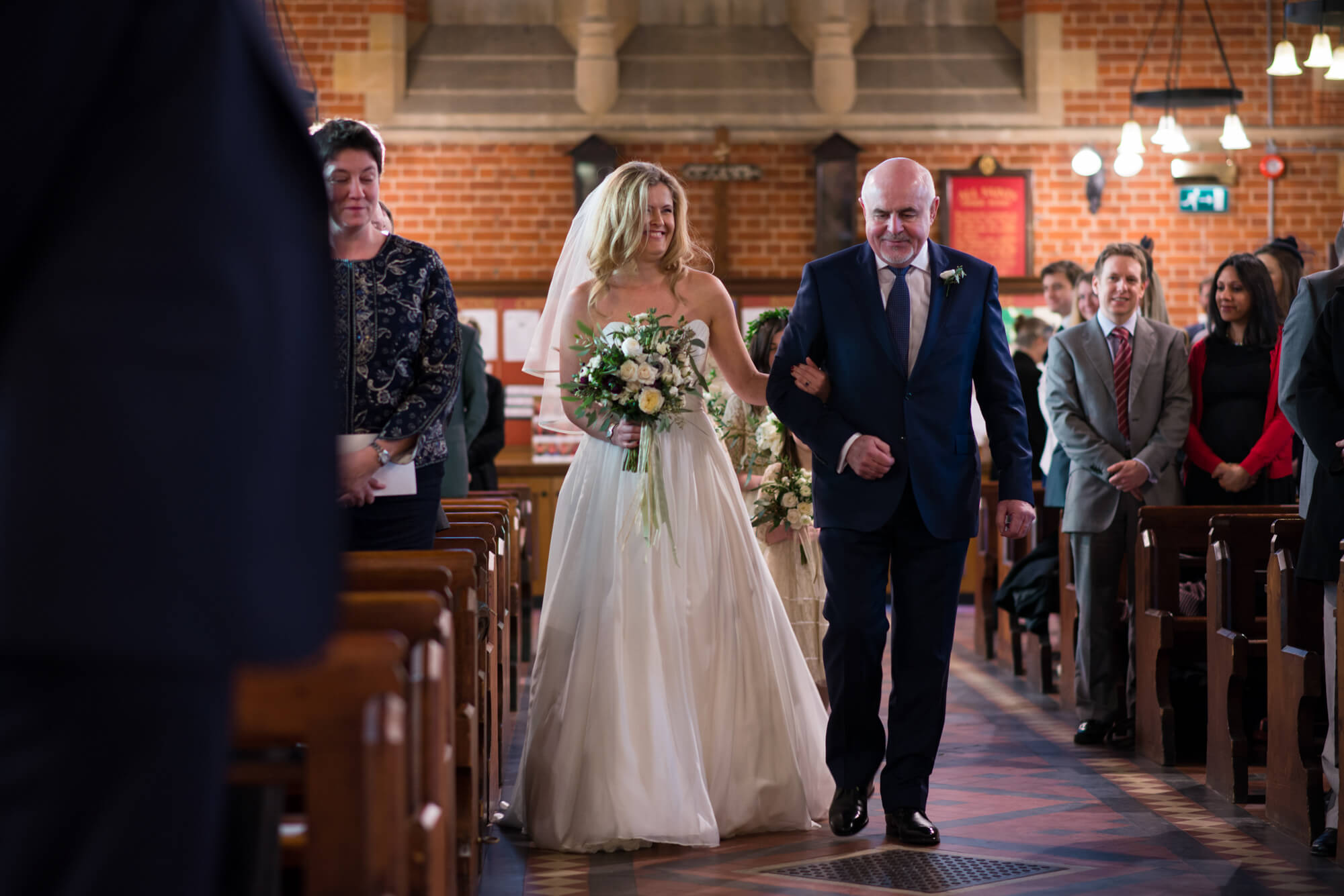 bride walking down the aisle with her dad at st marys church in putney in a naomi noeh wedding dress and whistles shoes