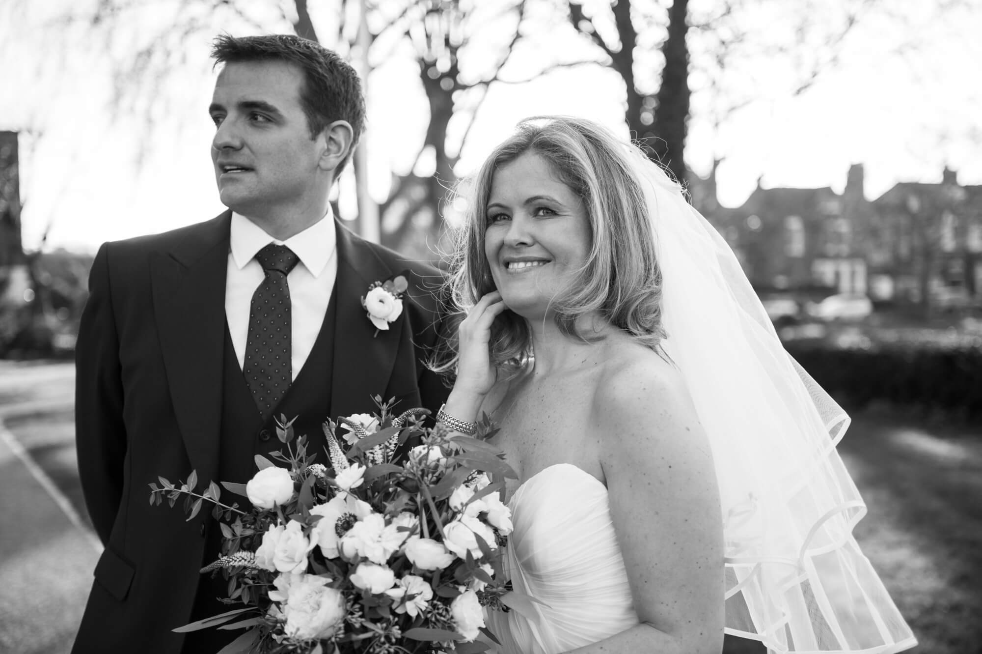 bride and groom outside of the church in putney wearing a beautiful naomi neoh bridal gown
