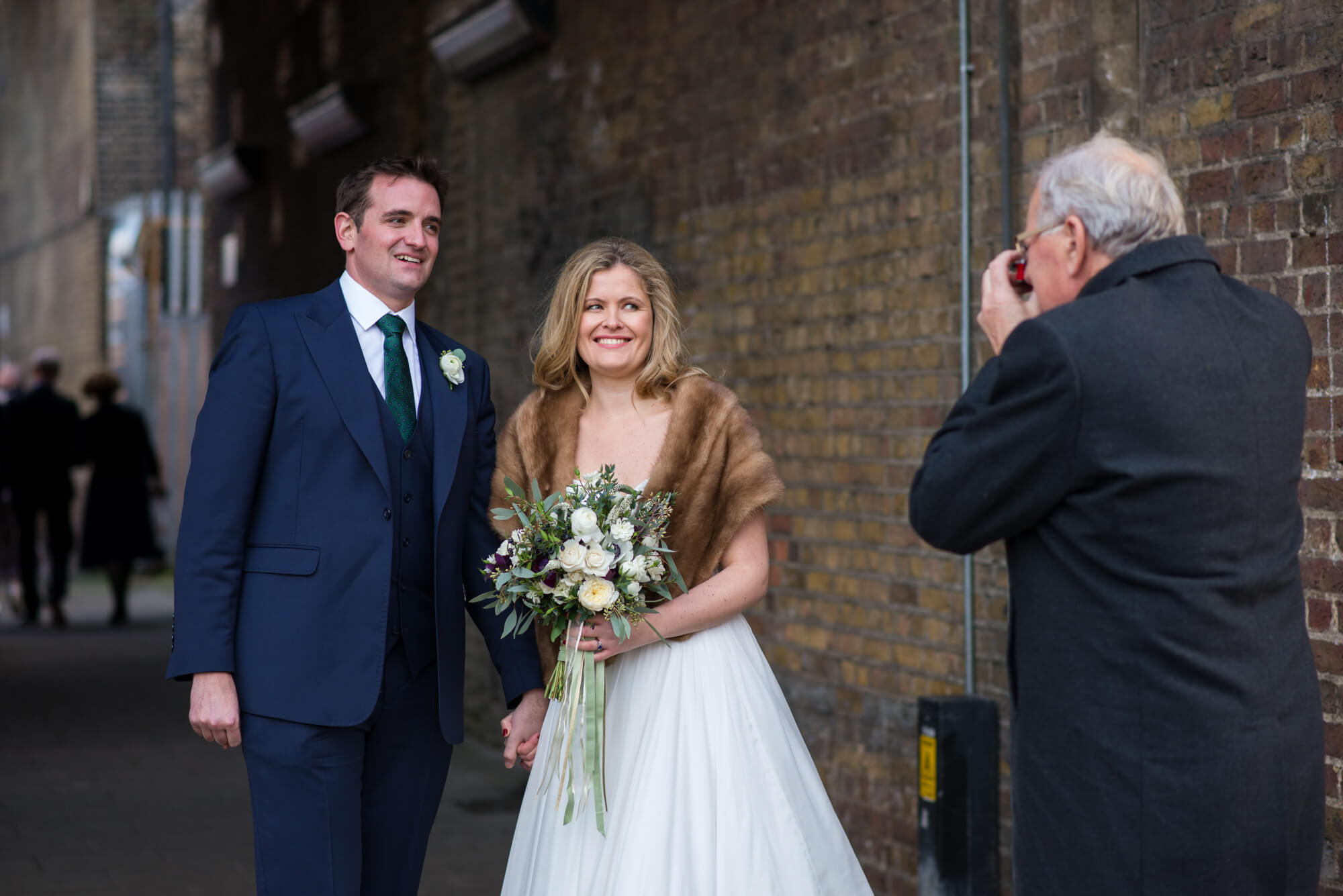 bride and groom being photographed under the arches at brixton east wedding venue in london