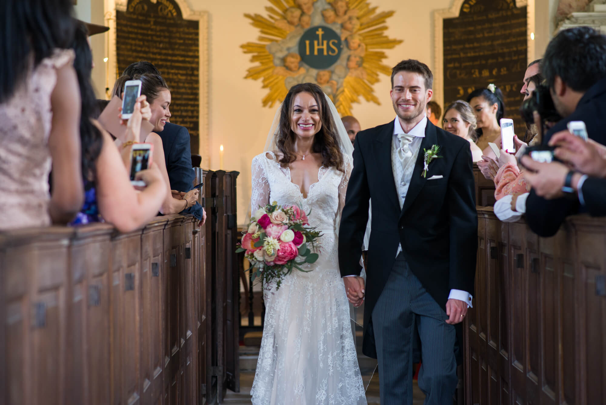 bride and groom walking down the aisle just married at st margarets chapel babington house
