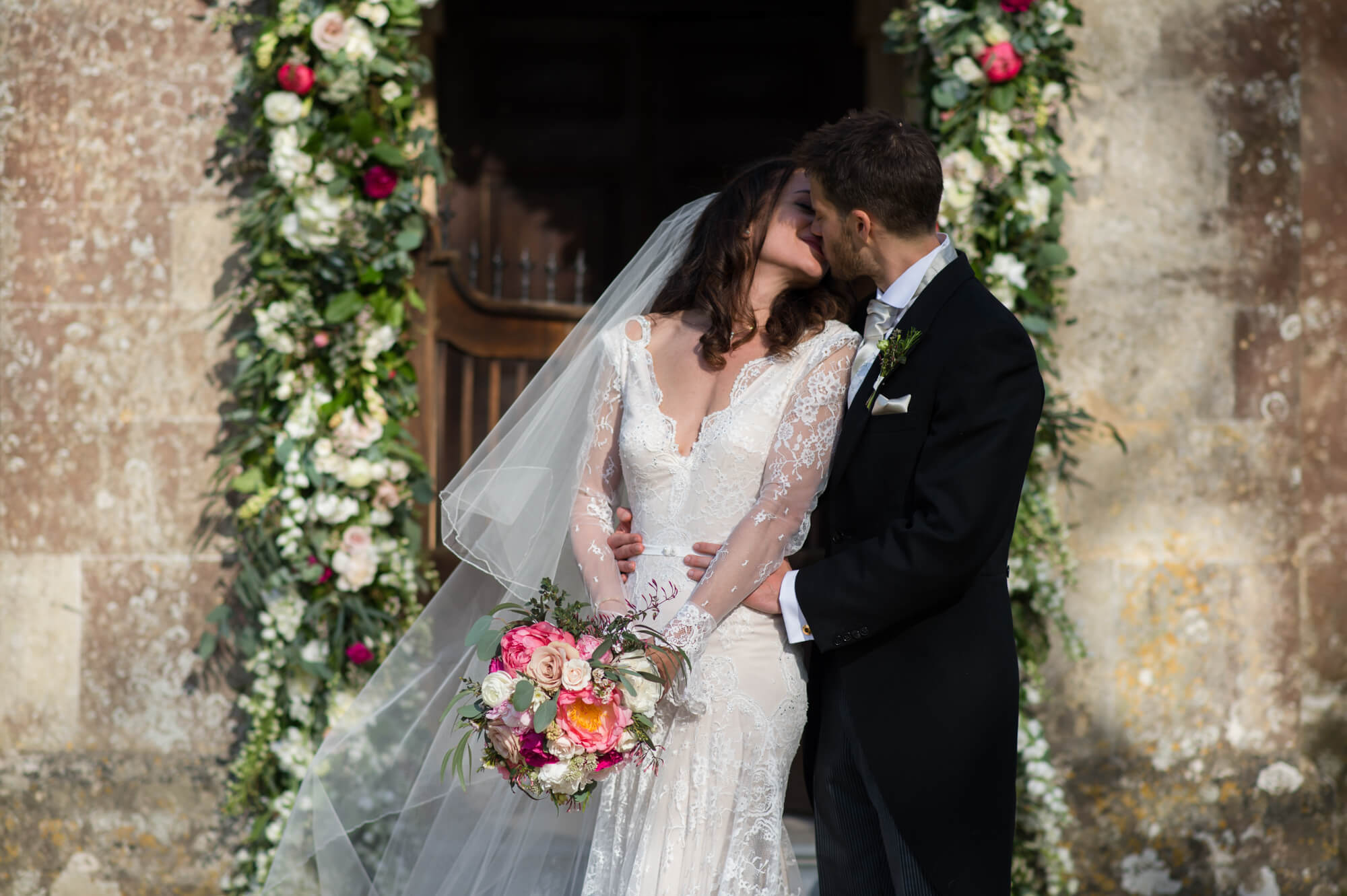 bride and groom just married outside st margarets chapel babington house wedding with rose arch in the spring