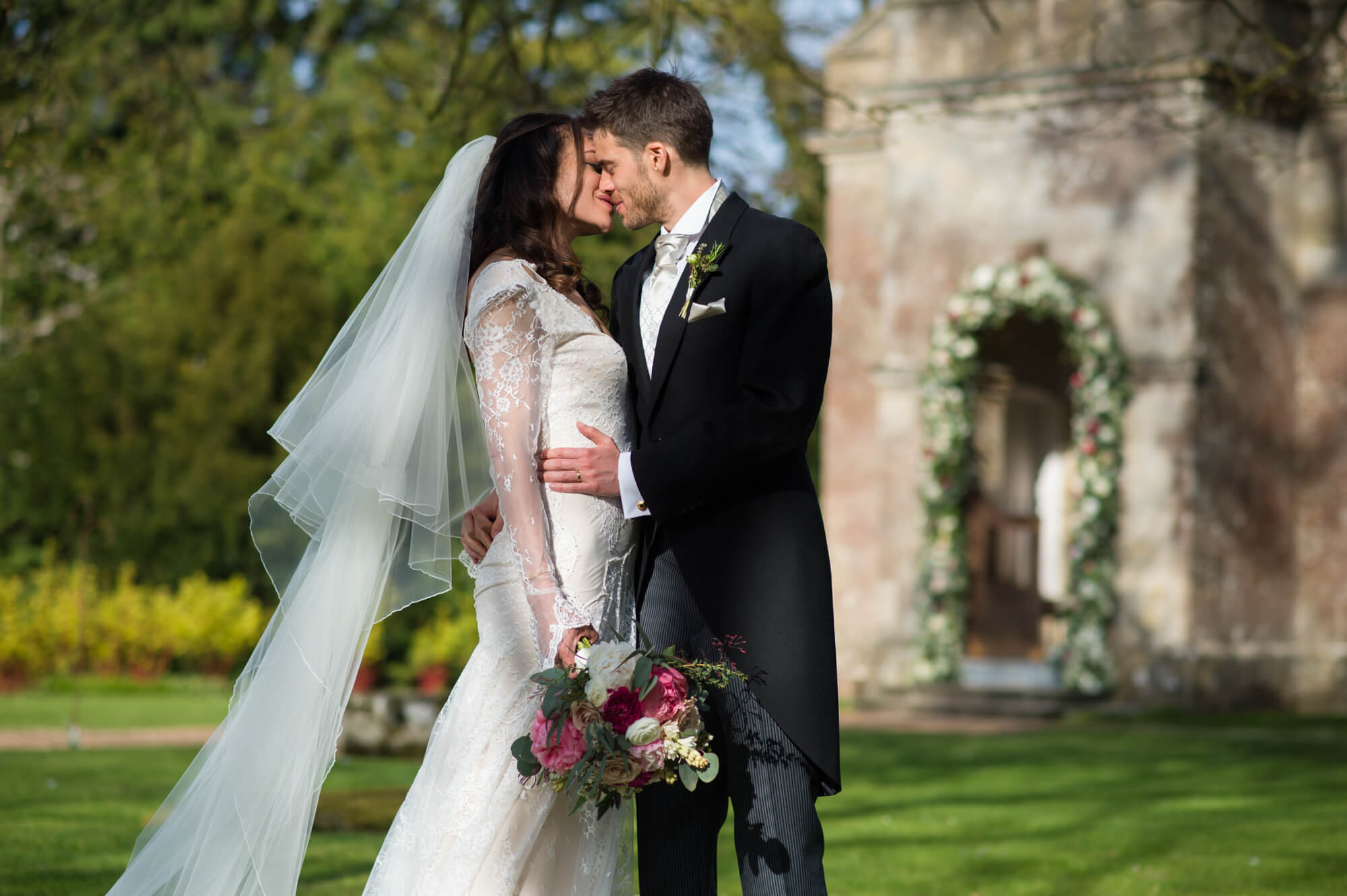 bride and groom just married outside st margarets chapel babington house wedding with rose arch in the spring