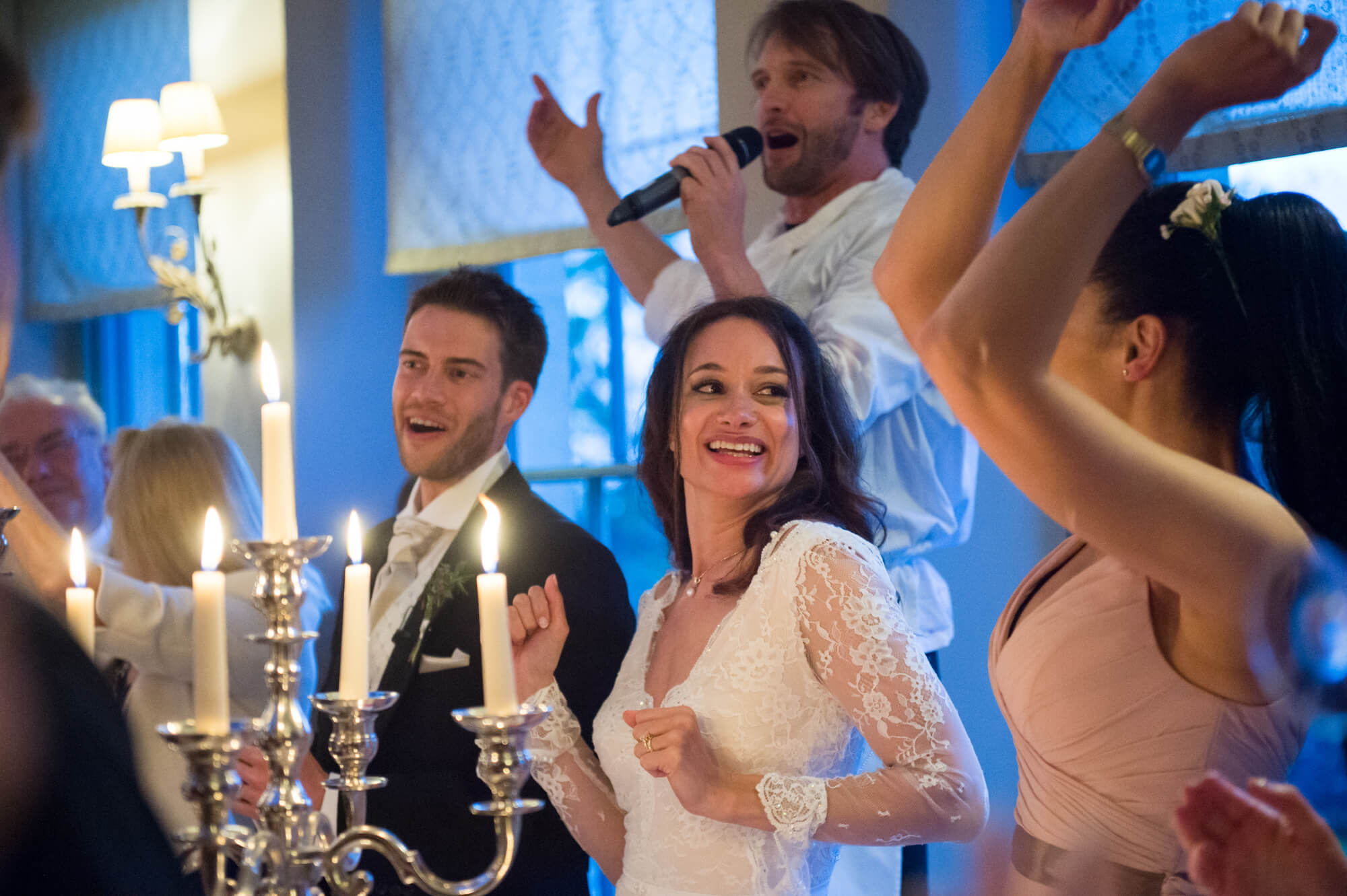 bride and singing waiters at babington house candlelit wedding reception in the orangery