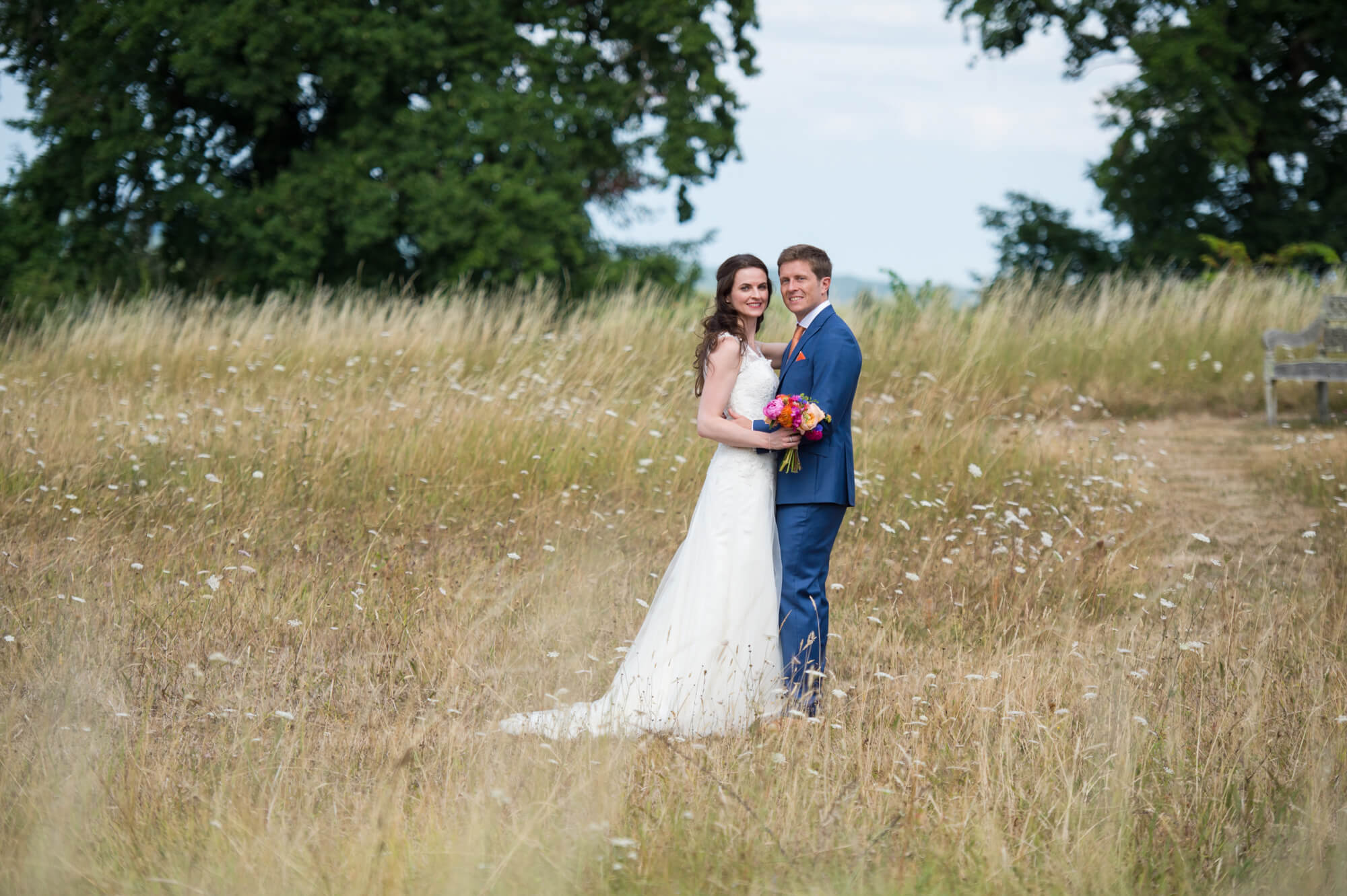 bride and groom standing in long grass at the meadow of chateau rigaud