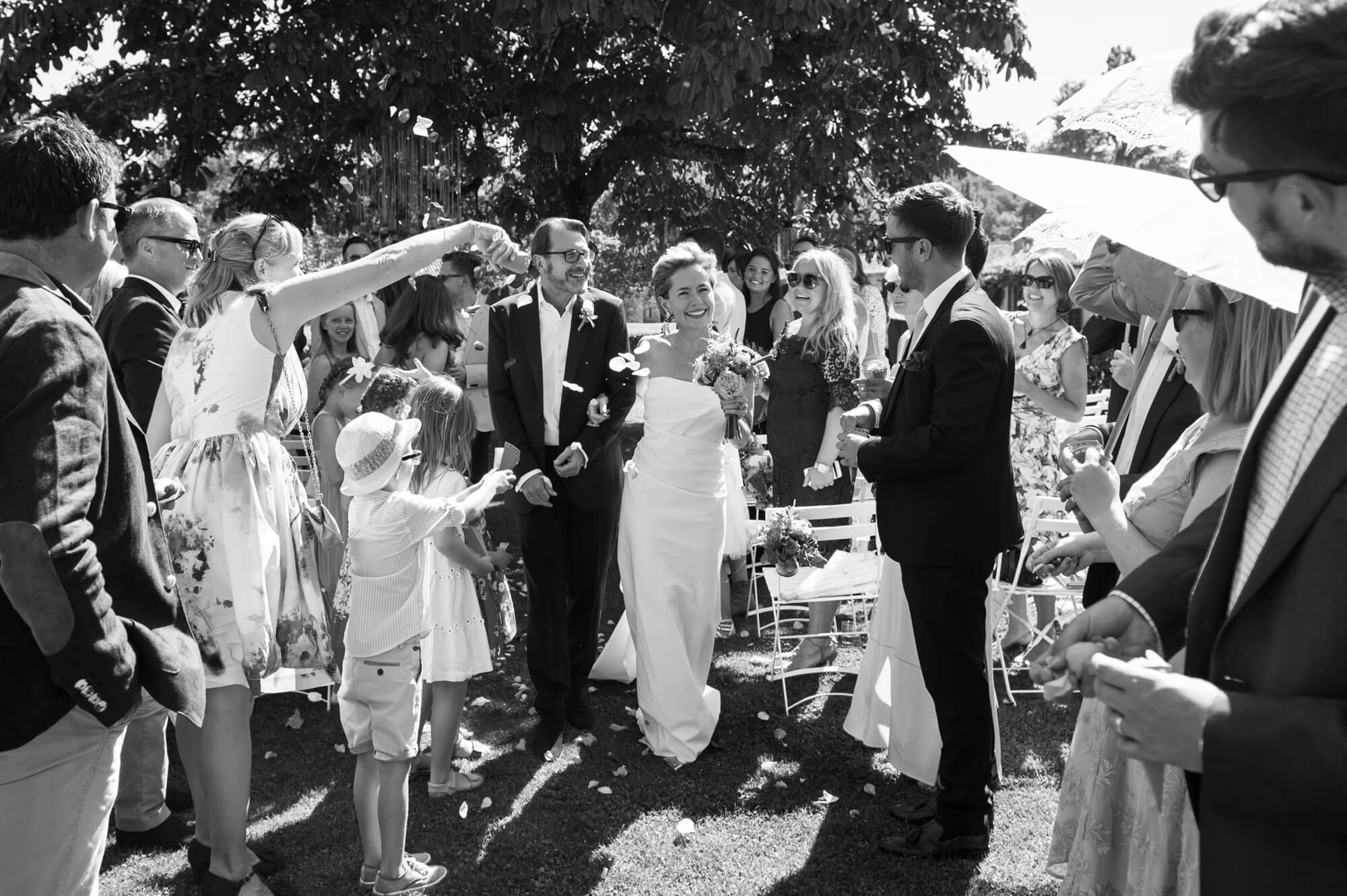 bride and groom walking down the aisle with confetti at chateau rigaud