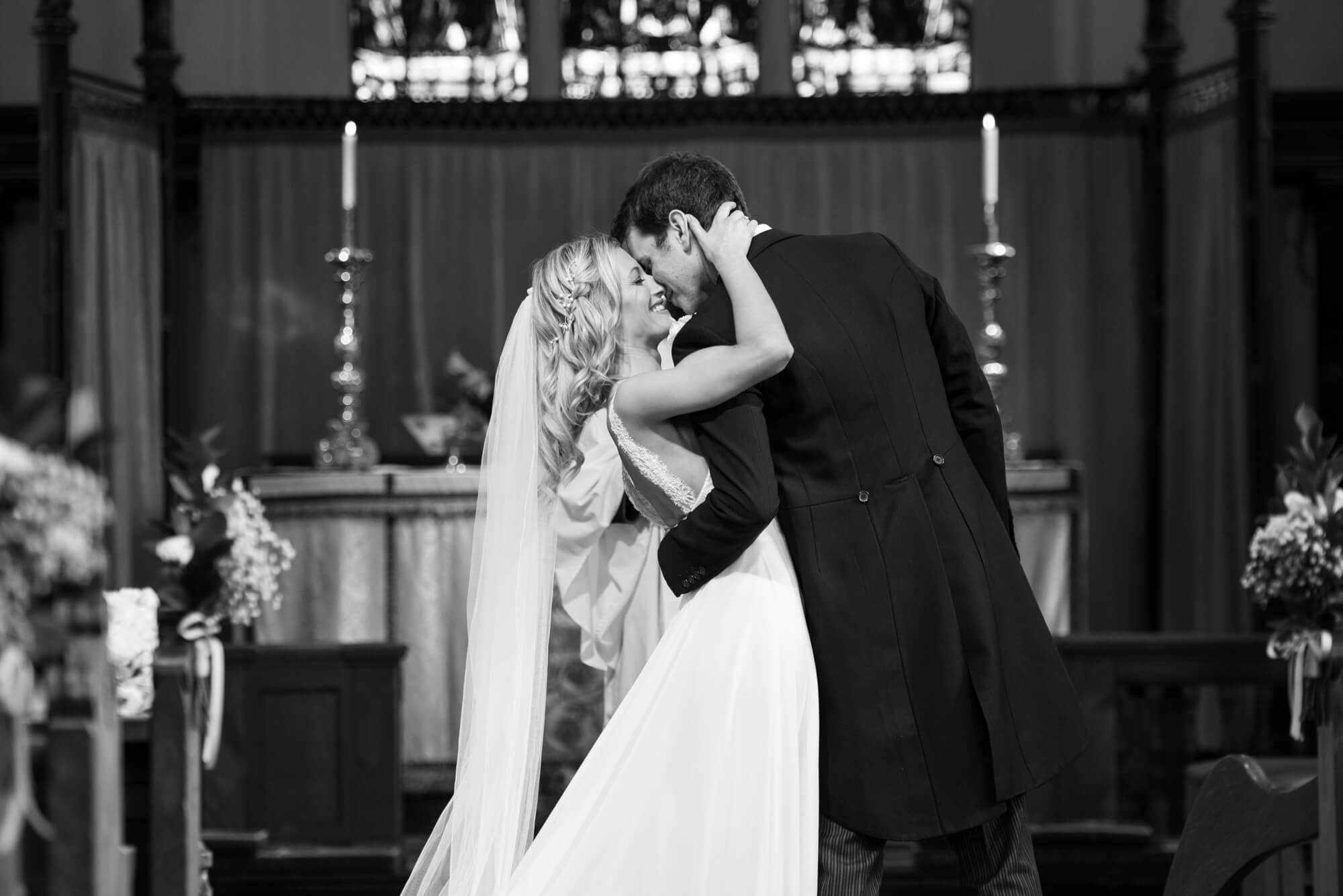 A bride and groom kissing at the altar after being declared married