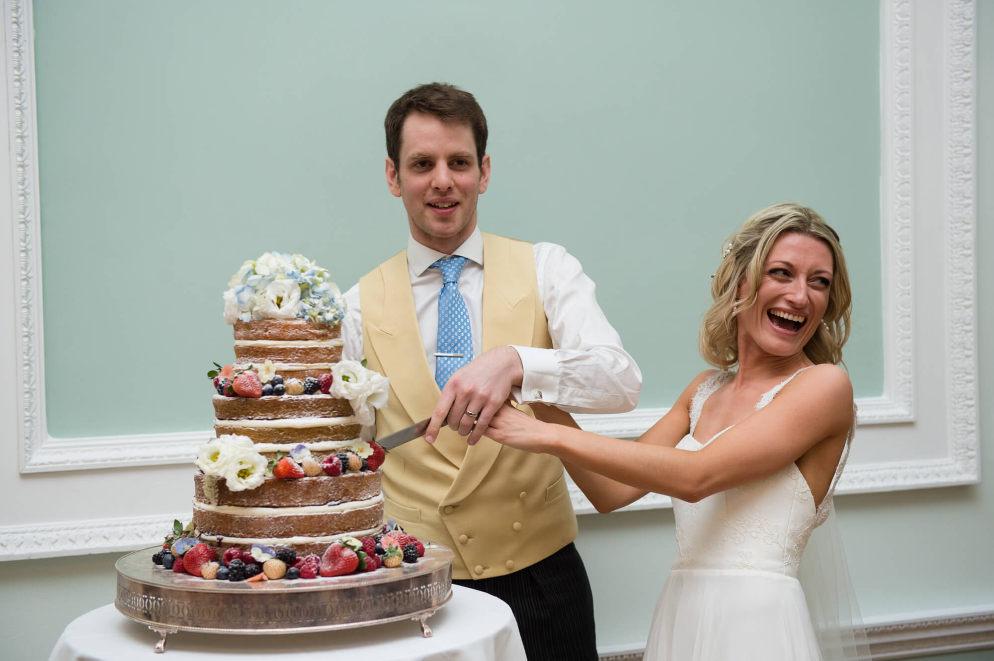 A bride and groom cutting their wedding cake made by Little Bear Cakery