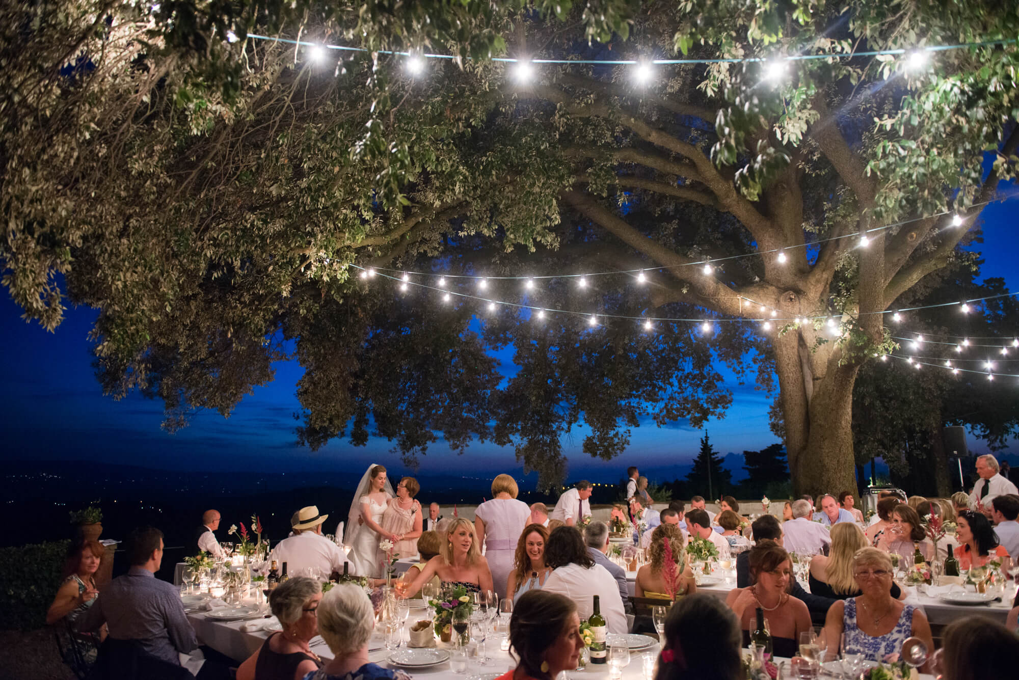 Wedding guests sitting at tables enjoying the celebrations in Tuscany, Italy 