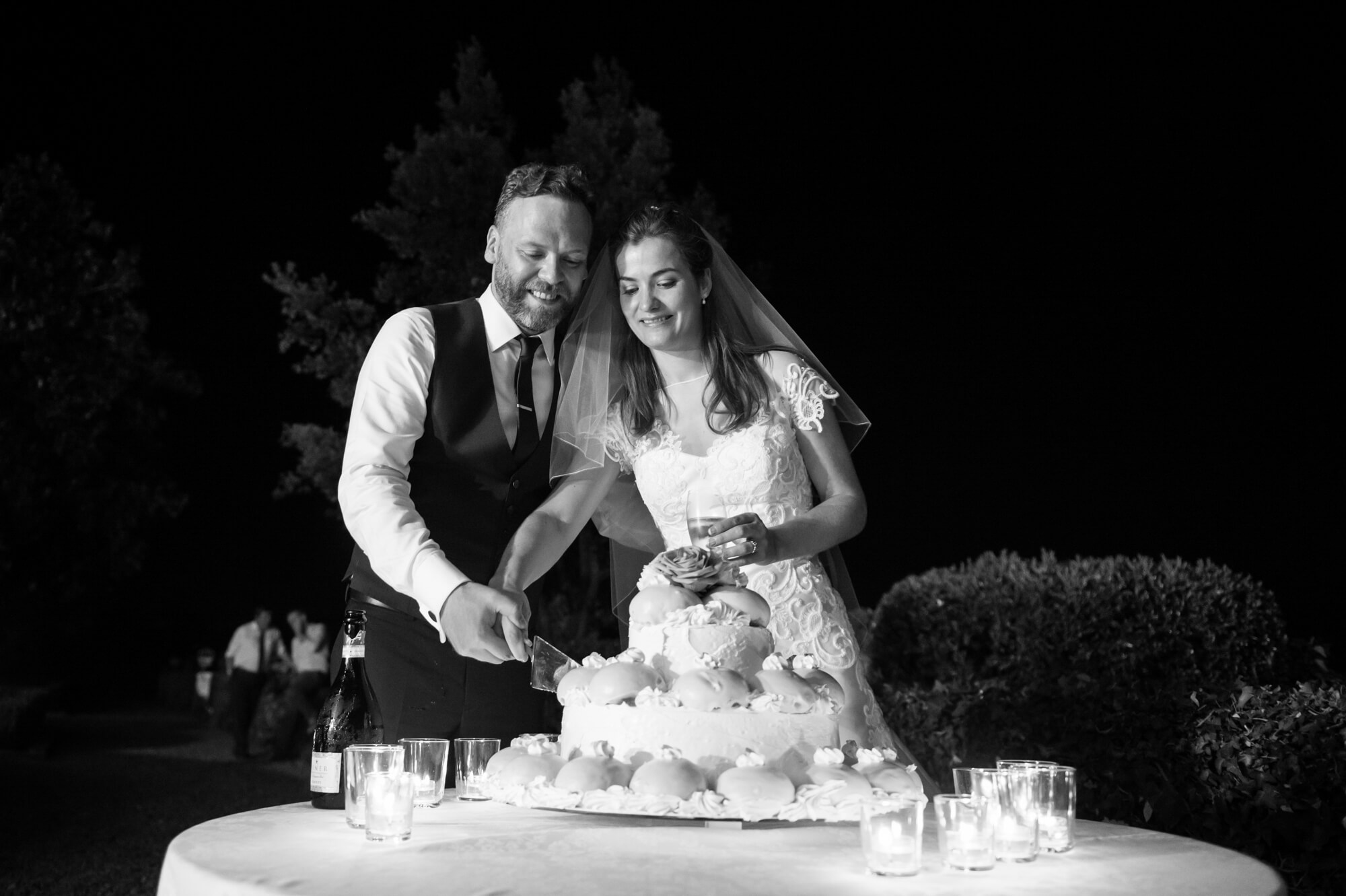 The bride and groom cutting the cake on their wedding day in Italy
